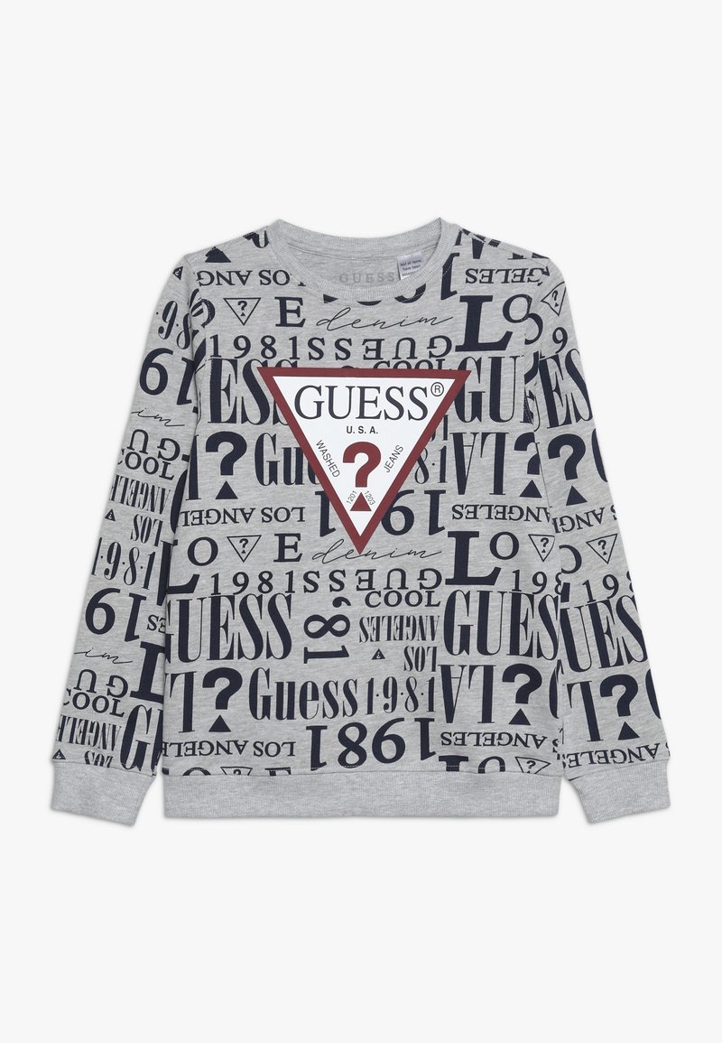 Sweat-shirt gris avec typographie mixte, affichant la marque "GUESS" dans un grand triangle rouge. Manches longues et encolure ronde.