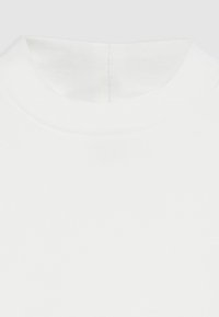 White cotton t-shirt featuring a rounded neckline and ribbed collar. The fabric is smooth with a slight sheen, designed for a minimalist look.
