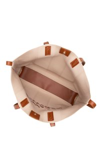 Sac en toile beige avec des poignées et des accents en cuir marron, doté d'un intérieur spacieux et d'un compartiment zippé au fond.