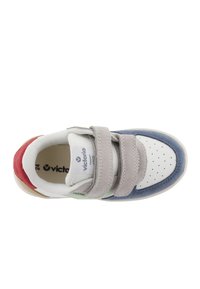 Sneaker grigia e blu navy con strap in Velcro, punta bianca perforata, dettagli verde e rosso, e un interno imbottito per il comfort.