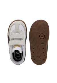 Sneaker per bambini in bianco e beige con due cinturini in velcro, interno nero etichettato "Kinderfit" e suola in gomma marrone antiscivolo con logo Puma.