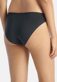 Fondo bikini nero realizzato in tessuto liscio, con un taglio a gamba alta e design minimalista. Nessun motivo visibile o dettagli in metallo.