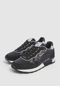 Black athletic shoes featuring a mix of textures with suede and mesh, white accents, a padded collar, and black laces.