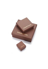 Rudos pakuotės langeliai skirtingų dydžių su blizgia tekstūra. Didžiausias langelis turi užrašą "Rafaela Donata" aukso spalvos raidėmis.