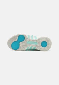 Suela de zapato deportivo azul claro con un patrón de espiga texturizado. Presenta acentos circulares azules y tres rayas blancas en el costado.