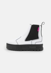 Hvit ankelstøvel med svart elastisk sidepanel, tykk svart såle, hvite sømmer og en liten rosa tab bak for enkel påkledning.