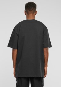 Sort oversized t-shirt lavet af bomuld, med rund halsudskæring og korte ærmer. Glat struktur uden synlige mønstre eller grafik.