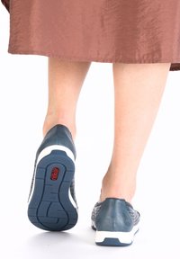 Blue leather slip-on shoes with a textured perforated design, white sole, and red logo detail on the heel, viewed from the back.