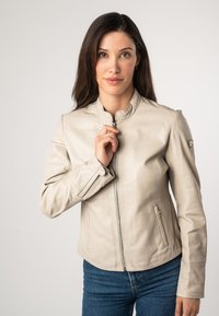 Lichtbeige leren jack met een opstaande kraag, een voorrits en zijzakken. Glad textuur met subtiele stikdetails.