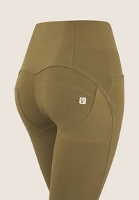 Leggings verde oliva con vita alta, pannelli testurizzati e una piccola accentatura del logo sulla tasca posteriore. Tessuto liscio e aderente.