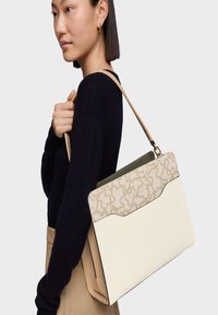 Bolso de hombro de cuero con un cuerpo crema, una solapa beige con estampado y un acento verde oliva. Diseño minimalista con una sola correa.