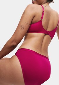 Fuchsiastek pink bikiniöverdel med justerbara remmar och spänne; matchande högmidjade bottnar; slät tygtextur; minimalistisk design.