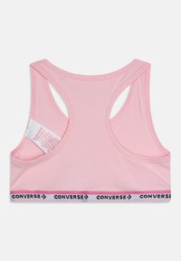 Rozā sporta krūšturis ar racerback dizainu, ar kontrastējošu melnu un baltu "CONVERSE" logos joslu apakšā. Izgatavots no mīksta, elastīga auduma.