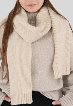 Beige knitted scarf with ribbed texture, draped loosely around a sweater. Soft material and clean edges, contributing to a cozy appearance.