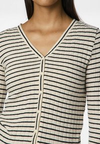 Cardigan beige à côtes avec des rayures horizontales noires, encolure en V et fermeture à cinq boutons à l'avant, avec une texture douce.
