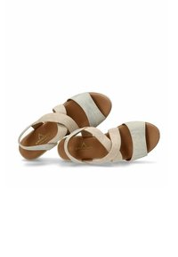 Sandalias beige y plateadas metálicas con amplias correas elásticas y una plantilla acolchada. Presenta un respaldo cerrado y una suela suave.