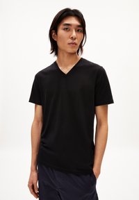 Zwarte T-shirt met korte mouwen en een V-hals ontwerp, gemaakt van zachte stof, met een ontspannen pasvorm en een gladde textuur.
