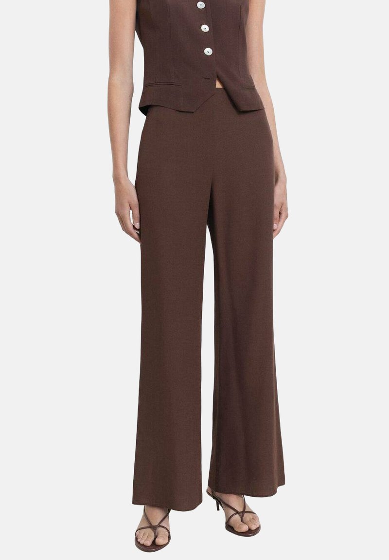 Bruine wijde broek van textuurstof, met een hoge taille, gladde afwerking en losse fit, gedragen met een bijpassende mouwloze top.
