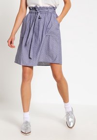 Sininen kuvioitu puuvillahame, jossa on korkea vyötärö, nyöri, ja kaksi etutaskua, sekä rento A-linjainen siluetti.