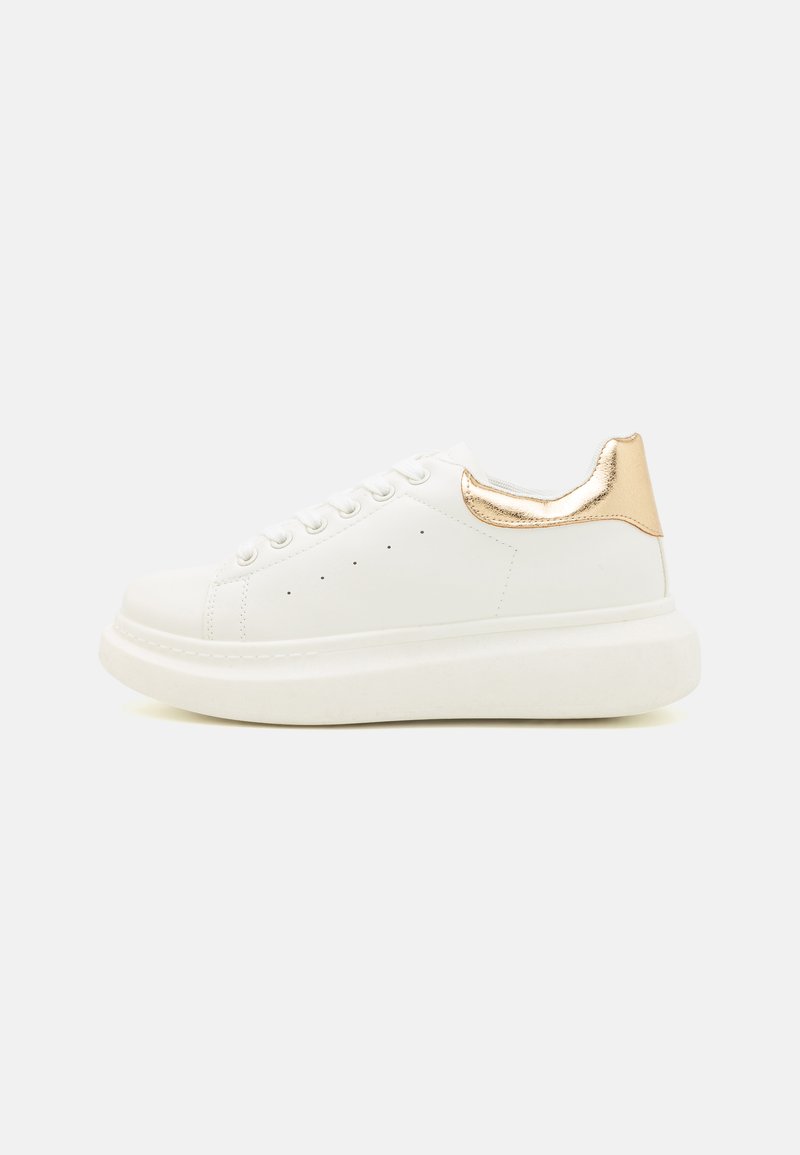 Hvit sneakers med en glatt lær overdel, metallisk gullaksett ved hælen, rund tå og en tykk, teksturert hvit såle.
