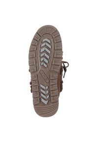 Brown footwear sole with a textured rubber surface. Features a zigzag tread pattern, flexible grooves, and raised rubber accents.