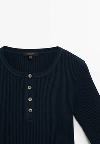 Mørkeblå ribbet langærmet top med rund halsudskæring, der har fem knapdetaljer og et mærke med teksten "Mango Man."