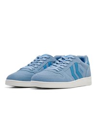 Niebieskie zamszowe sneakersy z białymi gumowymi podeszwami i sznurowadłami. Posiadają ciemniejsze niebieskie paski i perforowane akcenty na czubku.