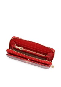 Portefeuille rouge à fermeture éclair tout autour, en matériau texturé, doté de multiples compartiments, emplacements pour cartes et ferrures ton or. L'intérieur est lisse et contrastant.