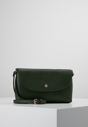 Sac bandoulière en cuir vert foncé avec rabat incurvé, fermeture par un seul bouton doré, et sangle réglable avec boucle dorée, présenté sur une surface blanche.