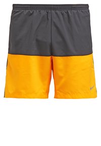 Shorts de sport pour hommes avec ceinture élastique, moitié supérieure gris foncé, moitié inférieure orange vif et petit logo réfléchissant sur la jambe droite.
