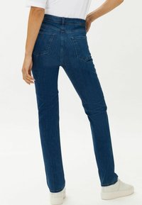 Jeans in denim blu scuro con un design aderente, stile a cinque tasche e una leggera elasticità. Rifiniti con una vita media e cuciture sottili.
