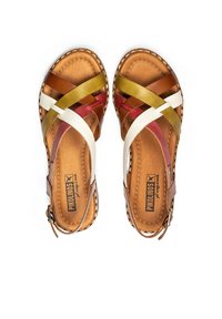 Bruna lädersandaler med tvärgående remmar i gult, vitt, rött och brunt. Har en låg klack och justerbart sidspänne. Sömnadsdetaljer.