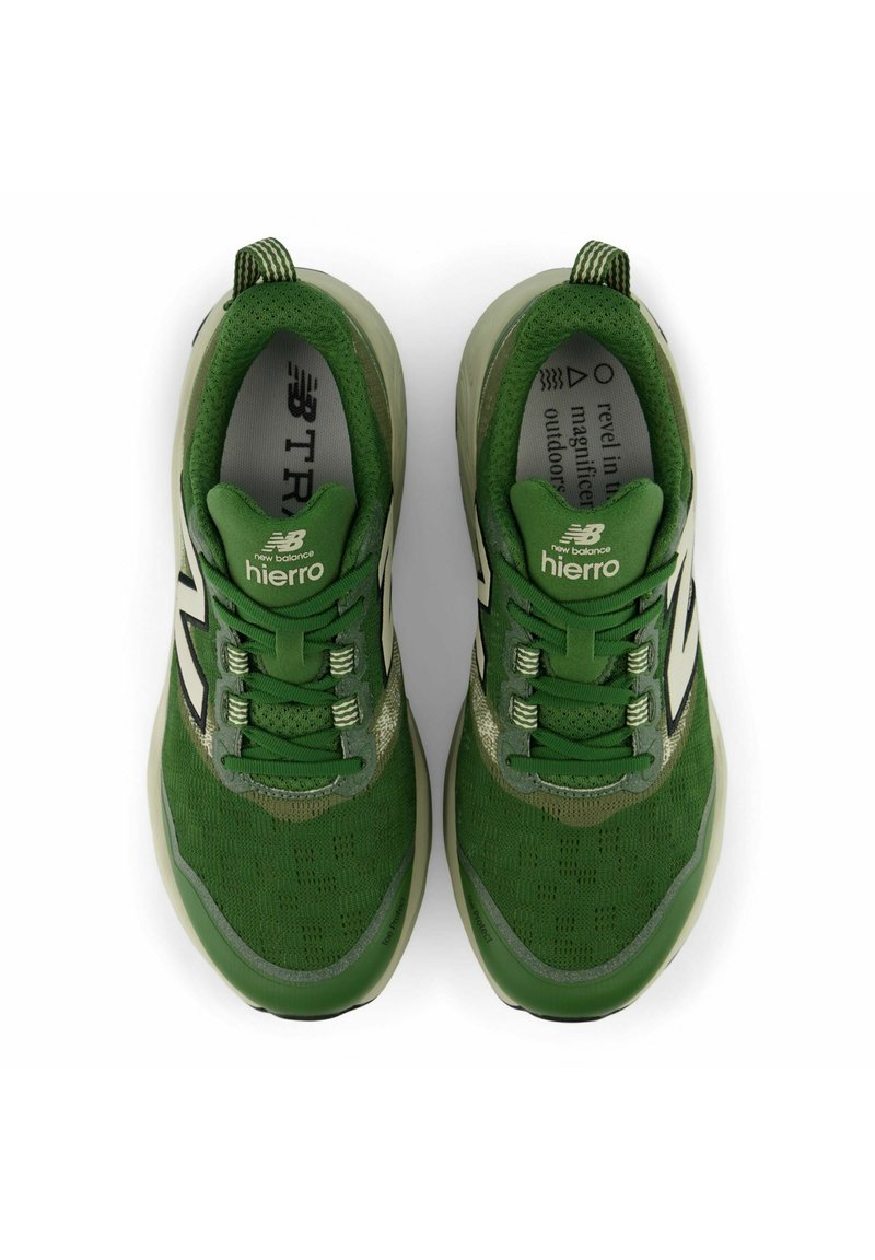 Grüne Sportschuhe mit einem strukturierten Mesh-Obermaterial, reflektierenden Akzenten, Schnürsenkeln und einer gepolsterten Sohle; ausgestattet mit dem "New Balance"-Logo.