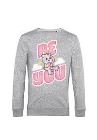 Sudadera gris con un gráfico de oso colorido, texto "SE TÚ MISMO" en rosa y acentos de arcoíris sobre un diseño de nube. Mangas largas con puños acanalados.