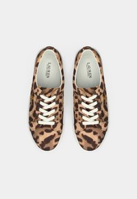 Ζευγάρι αθλητικών παπουτσιών Lauren Ralph Lauren με καφέ και μαύρο λεοπάρ μοτίβο και λευκά κορδόνια, εμφανίζονται από πάνω σε λευκό φόντο.