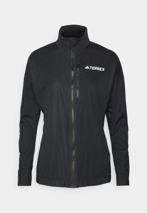 Die schwarze Terrex-Jacke verfügt über einen hohen Kragen, einen Frontreißverschluss und einen glatten, leichten Stoff mit einem gestickten Logo auf der Brust.