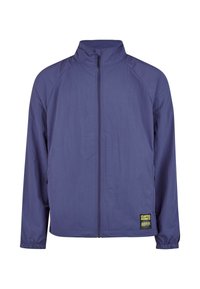 Lila Reißverschlussjacke mit hohem Kragen, leichtem Material, elastischen Bündchen und einem markanten Logo-Patch auf der linken Seite.