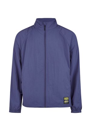 Purple zipper jacket with high collar, lightweight fabric, elastic cuffs, and a distinctive logo patch on the left side.