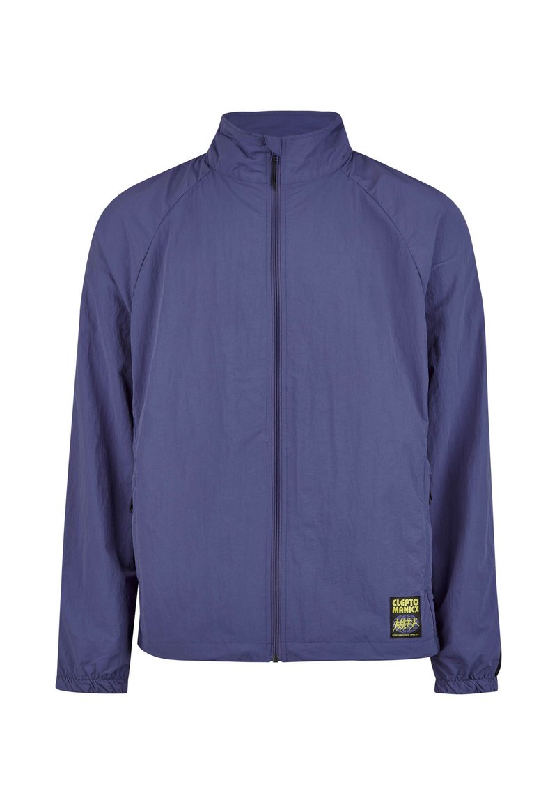 Lila Reißverschlussjacke mit hohem Kragen, leichtem Material, elastischen Bündchen und einem markanten Logo-Patch auf der linken Seite.