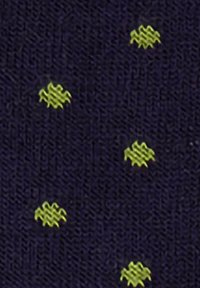 Dunkles Gewebe mit einem strukturierten Strickmuster, das kleine, verstreute gelbe Zickzack-Stiche zeigt.