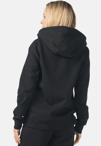 Felpa nera con cappuccio dal taglio ampio, dotata di un cappuccio spazioso, maniche lunghe e polsini e orlo a costine. Tessuto morbido in misto cotone.