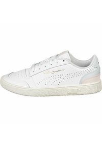 Białe skórzane sneakersy z perforowanymi detalami, jasnoróżowymi akcentami i teksturowaną gumową podeszwą. Logo PUMA i złoty podpis po boku.