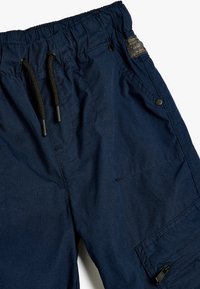 Marineblauwe cargoshorts van stof met een elastische tailleband, trekkoord, meerdere zakken en contrasterende stikseldetails.