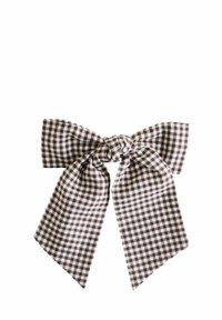 Gingham-stiilis juuksepael sõlme keskosaga, mis on kaetud pruun-valge ruudustikuga. Kangas on sileda tekstuuriga, laiade ja sümmeetriliste sabadega.