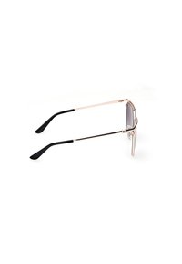 Ochelari de soare metalici cu cadru auriu și lentile gri. Vârfuri ale bratelor din plastic negru. Design subțire cu o formă liniară și detalii hardware minime.
