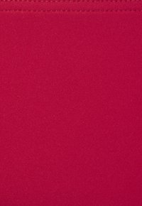 Helle rote Stoff mit einer glatten, leicht strukturierten Oberfläche. Zeigt eine gleichmäßige Farbe mit subtiler Glanz und sauberer Naht entlang der Kanten.