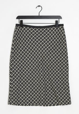 Jupe à carreaux noir et blanc en textile tissé, dotée d'une taille ajustée et d'une forme légèrement évasée. Accrochée à un cintre noir.