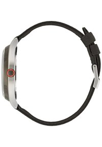 Klocka i rostfritt stål med rund urtavla, svart texturerad vävrem och en röd accentuerad knapp. Tydliga timmarkörer och elegant design.