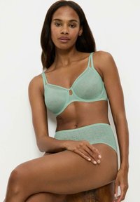 Miętowy zestaw bielizny składający się z teksturowanego biustonosza z regulowanymi ramiączkami oraz majtek. Tkanina ma subtelny wzór i gładkie wykończenie.