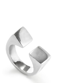 Bague en métal argenté avec un design ouvert unique présentant deux extrémités carrées. Texture lisse avec une finition polie, reflétant la lumière.